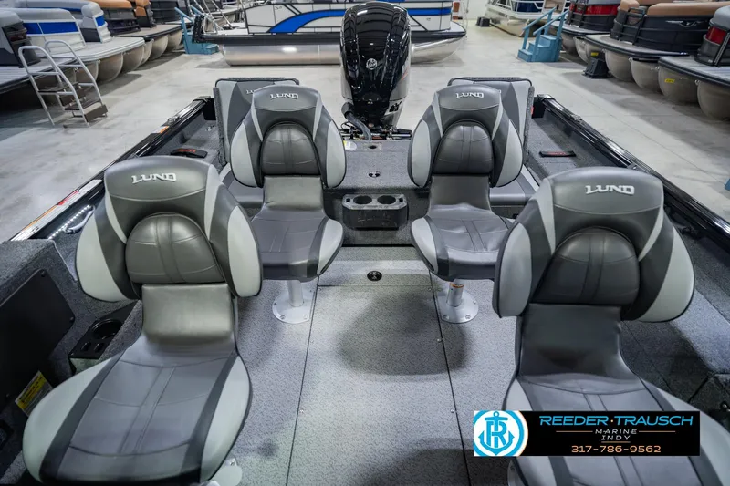 Slide: The Image of 2026 Lund 1775 Impact XS boat interior with four gray seats in showroom. - 18