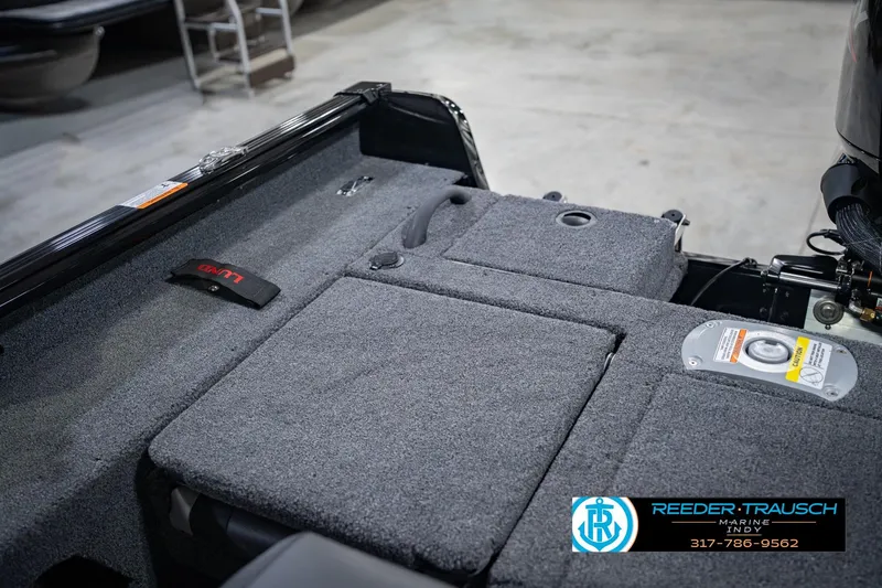 Slide: The Image of 2026 Lund 1775 Impact XS boat interior with carpeted deck and storage compartments. - 21