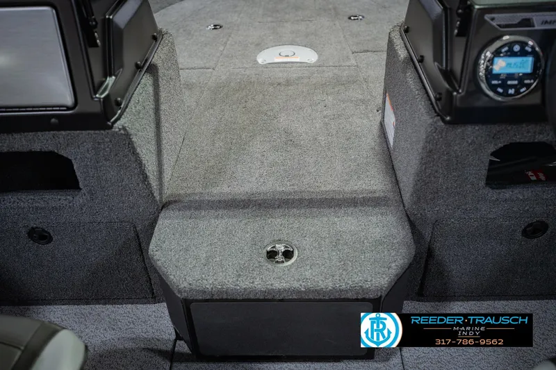 Slide: The Image of 2026 Lund 1775 Impact XS boat interior with carpeted flooring and dashboard controls. - 29