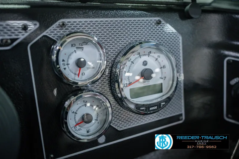 Slide: The Image of Dashboard gauges of 2026 Lund 1775 Impact XS boat, featuring trim and fuel indicators. - 35