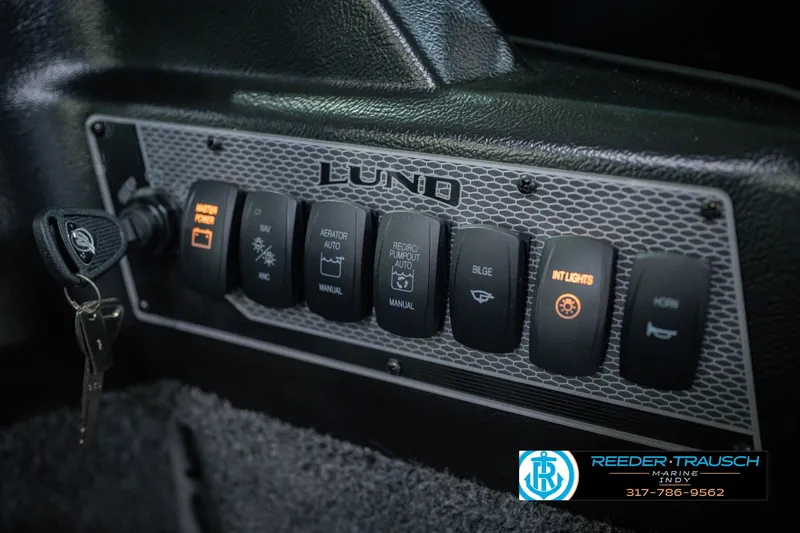 Slide: The Image of Control panel of 2026 Lund 1775 Impact XS boat with various switches and key ignition. - 37