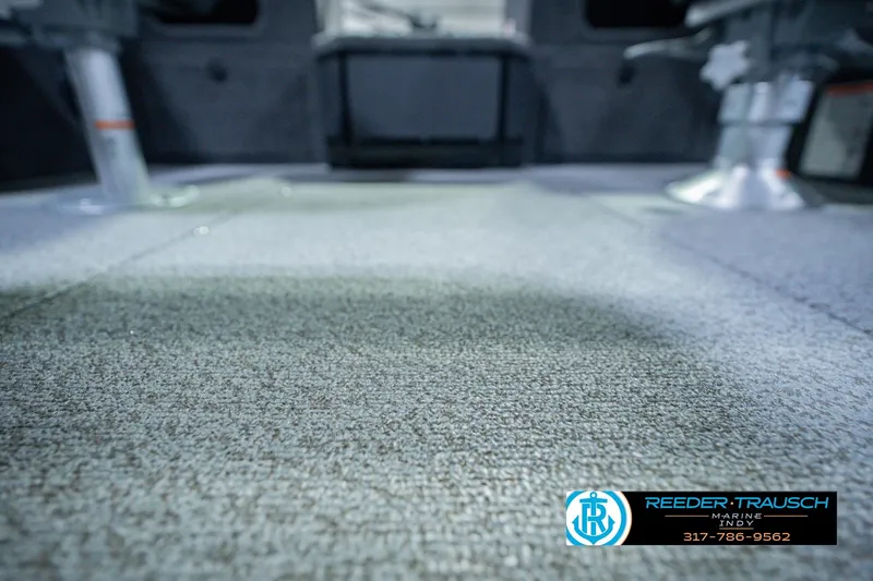 Slide: The Image of 2026 Lund 1775 Impact XS boat interior with carpeted flooring and seating. - 49