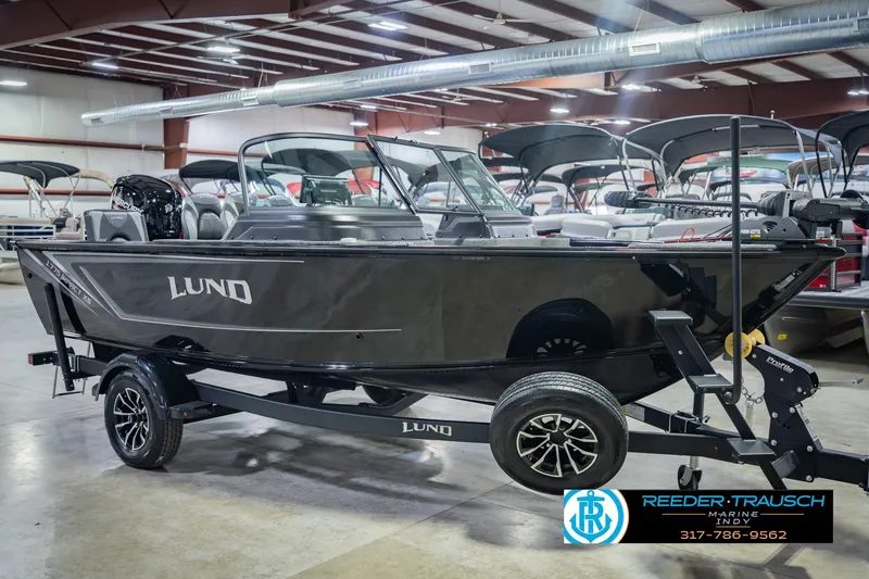 Slide: The Image of 2026 Lund 1775 Impact XS boat displayed indoors on a trailer. - 5