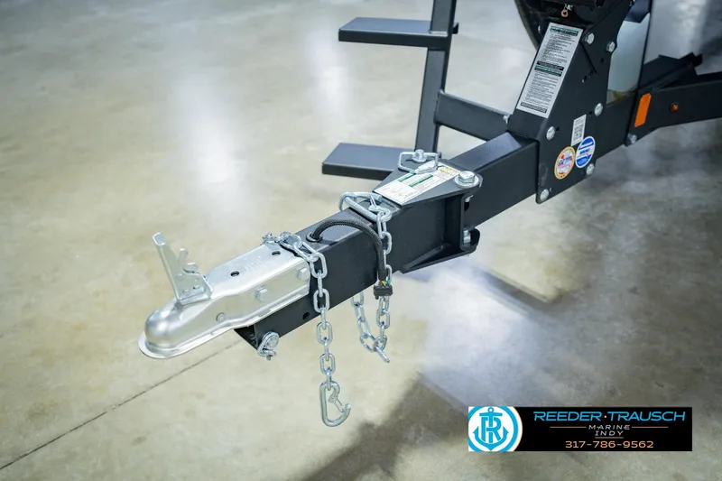 Slide: The Image of Trailer hitch of 2026 Lund 1775 Impact XS boat, secured with chains, on showroom floor. - 61