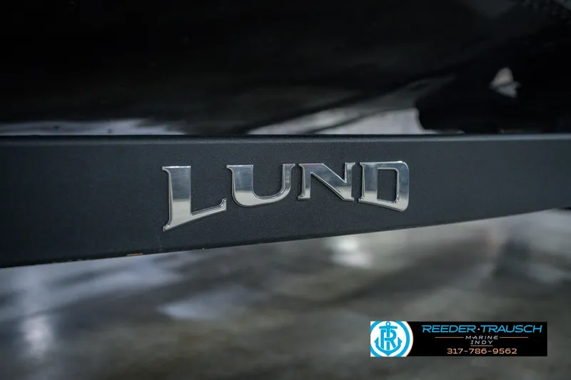 Slide: The Image of Close-up of 2026 Lund 1775 Impact XS boat logo on a dark surface. - 63