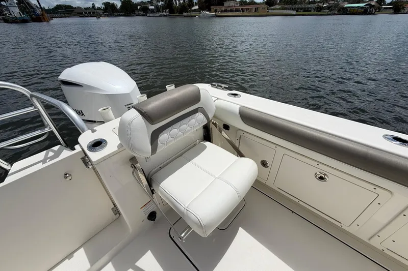 Slide: The Image of 2020 World Cat 295 CC boat interior with seating and Yamaha engine by the water. - 10