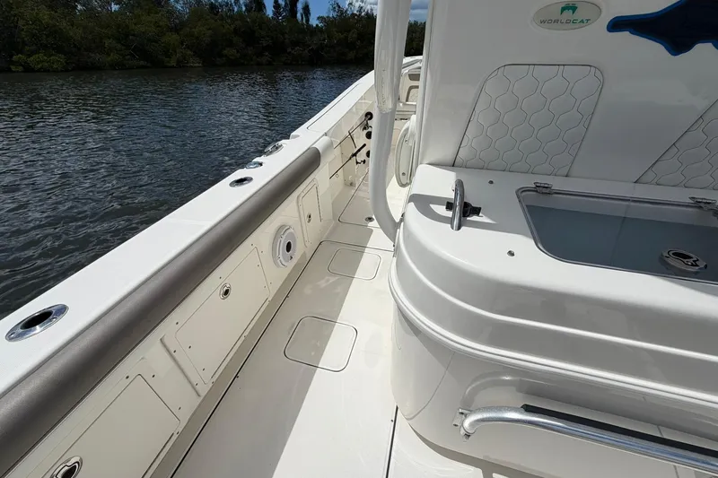 Slide: The Image of 2020 World Cat 295 CC boat interior with seating and storage, near water. - 12