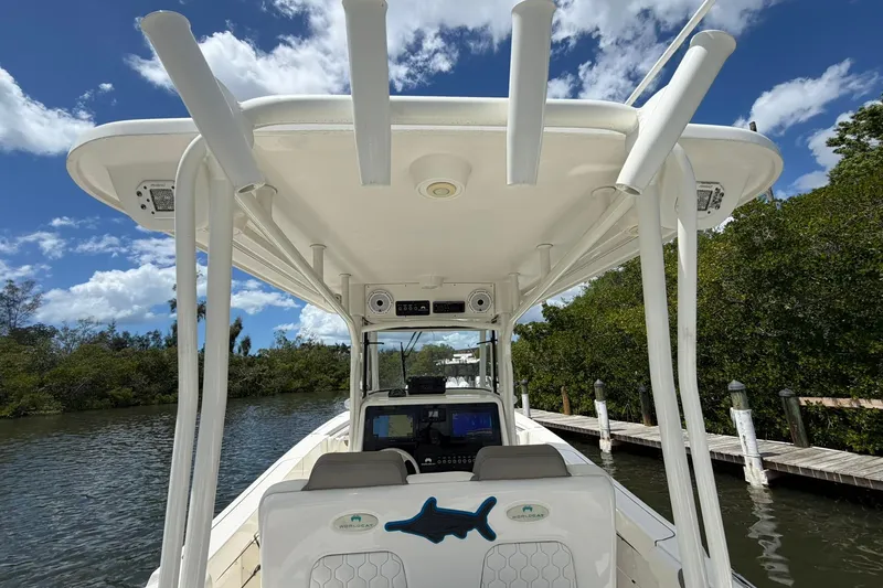 Slide: The Image of 2020 World Cat 295 CC boat interior with canopy, docked by lush greenery. - 14
