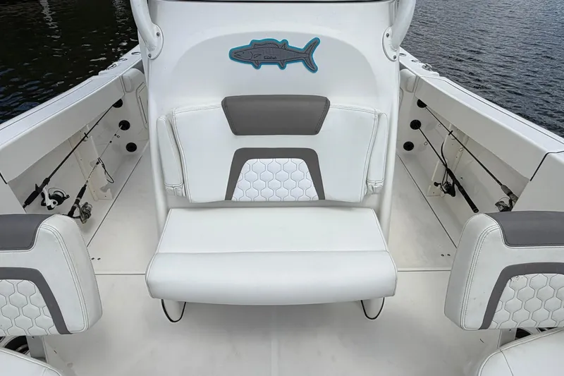 Slide: The Image of 2020 World Cat 295 CC boat interior with white seating and fishing rod holders. - 27