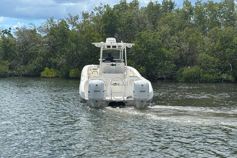 Slide: The Image of 2020 World Cat 295 CC boat cruising on a calm river near lush greenery. - 7
