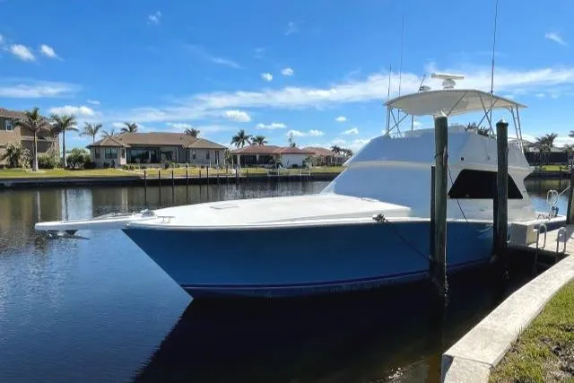 The Image of 1999 Viking 50 Convertible yacht docked in a serene waterfront setting. - 0