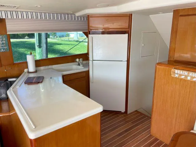 Slide: The Image of Interior of 1999 Viking 50 Convertible yacht with kitchen and wooden cabinetry. - 23