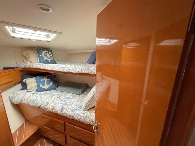 Slide: The Image of Cozy cabin with bunk beds in 1999 Viking 50 Convertible yacht, featuring nautical-themed decor. - 41