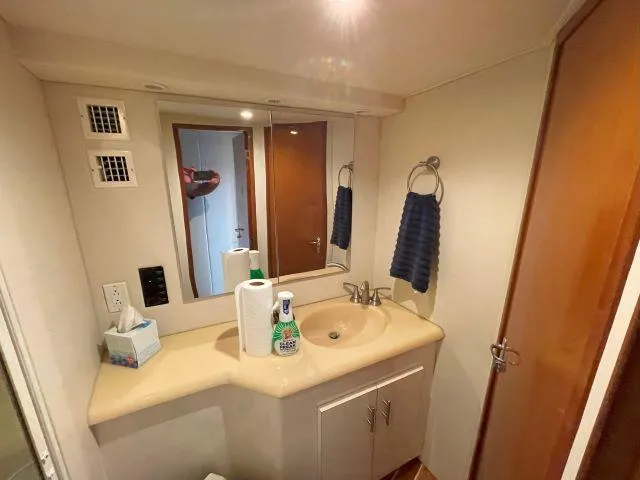 Slide: The Image of Bathroom interior of a 1999 Viking 50 Convertible yacht, featuring a sink and mirror. - 43