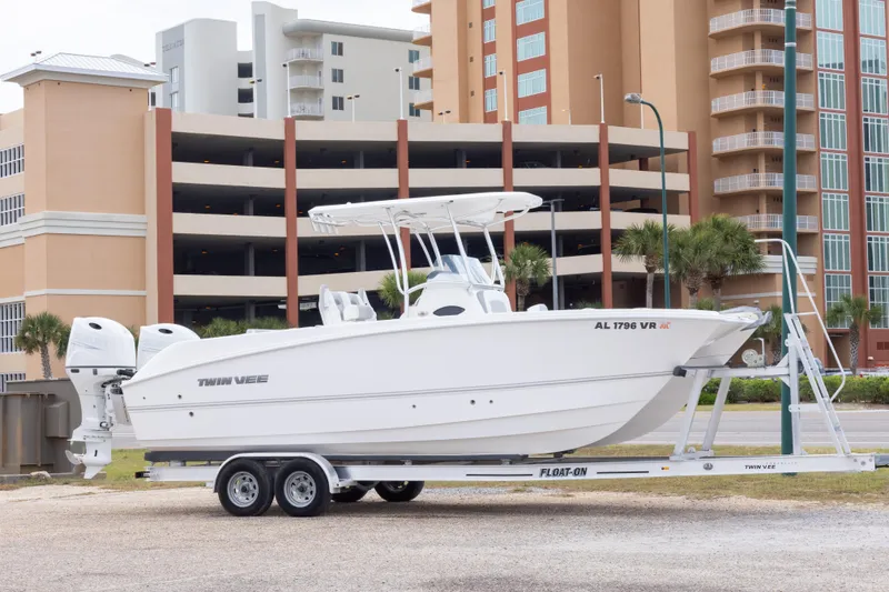 The Image of 2022 Twin Vee 240 GFX CC boat on trailer, urban background. - 1
