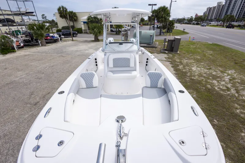 Slide: The Image of 2022 Twin Vee 240 GFX CC boat with spacious seating, parked near a road. - 10