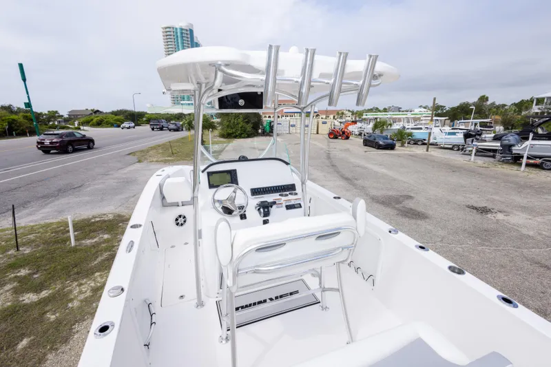 Slide: The Image of 2022 Twin Vee 240 GFX CC boat with modern console and seating, parked near a road. - 12