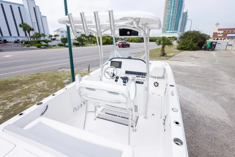 Slide: The Image of 2022 Twin Vee 240 GFX CC boat with modern console, parked near a road and buildings. - 13