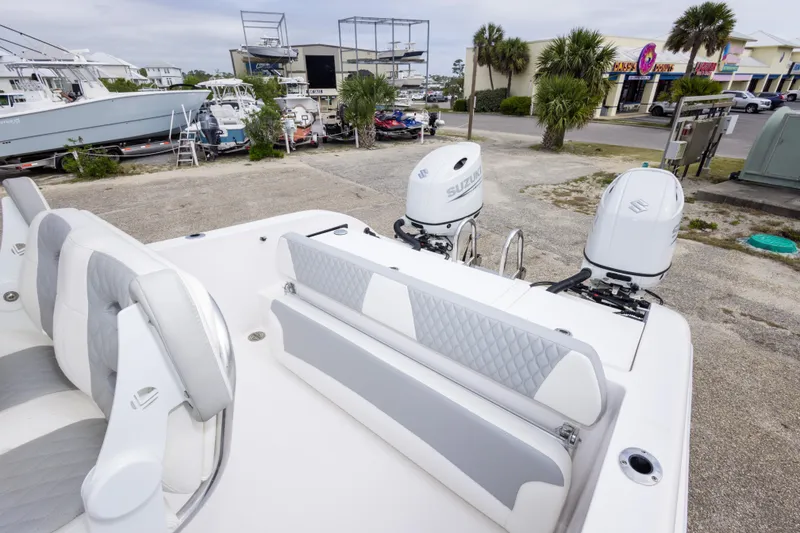 Slide: The Image of 2022 Twin Vee 240 GFX CC boat with dual Suzuki outboard motors in a marina setting. - 17
