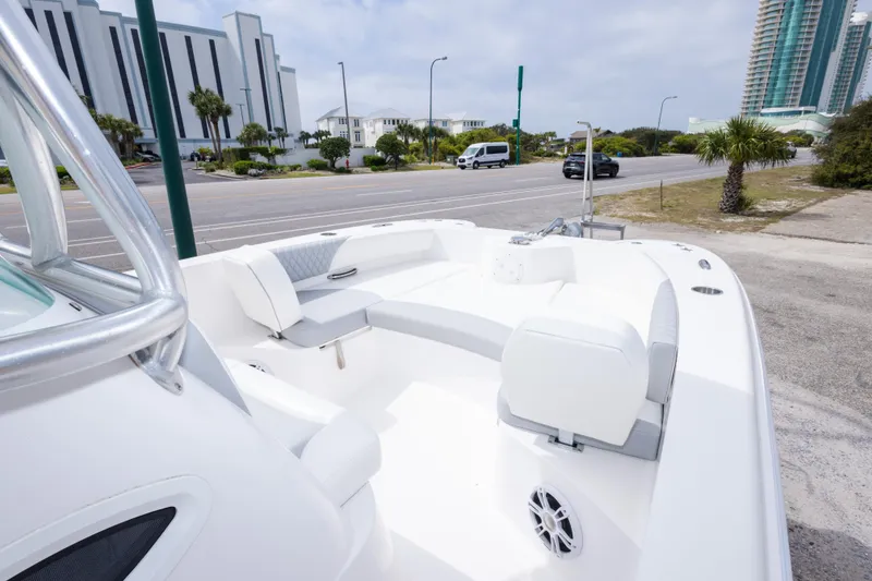 Slide: The Image of 2022 Twin Vee 240 GFX CC boat with white seating, parked near a coastal road. - 25