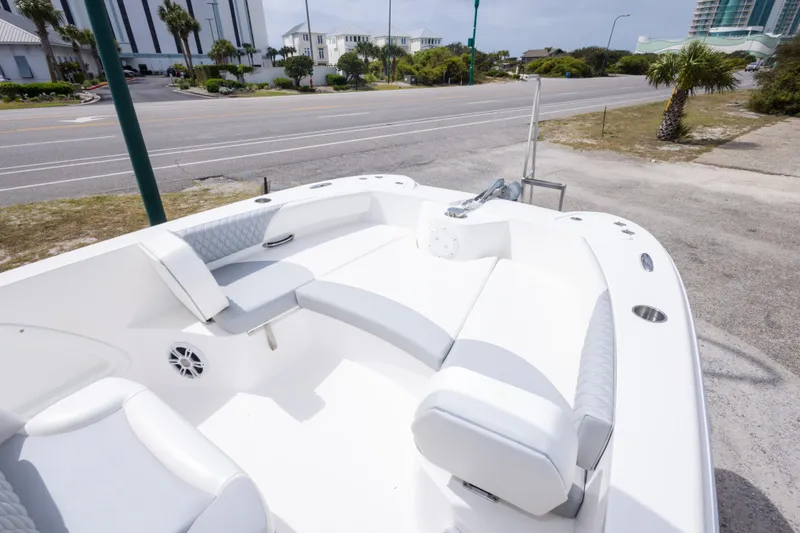 Slide: The Image of 2022 Twin Vee 240 GFX CC boat with spacious seating, parked near a coastal road. - 27