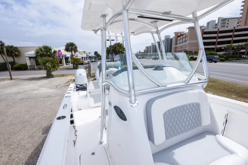 Slide: The Image of 2022 Twin Vee 240 GFX CC boat with sleek design, parked near coastal buildings. - 30