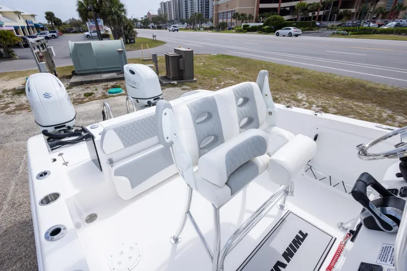 Slide: The Image of 2022 Twin Vee 240 GFX CC boat interior with dual Suzuki engines, parked near a road. - 31