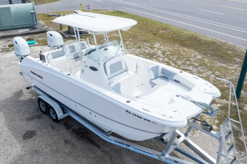 Slide: The Image of 2022 Twin Vee 240 GFX CC boat on trailer, white exterior, dual engines, parked roadside. - 36