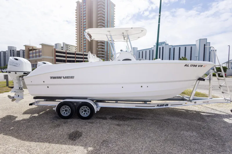 Slide: The Image of 2022 Twin Vee 240 GFX CC boat on trailer, urban background, sunny day. - 4