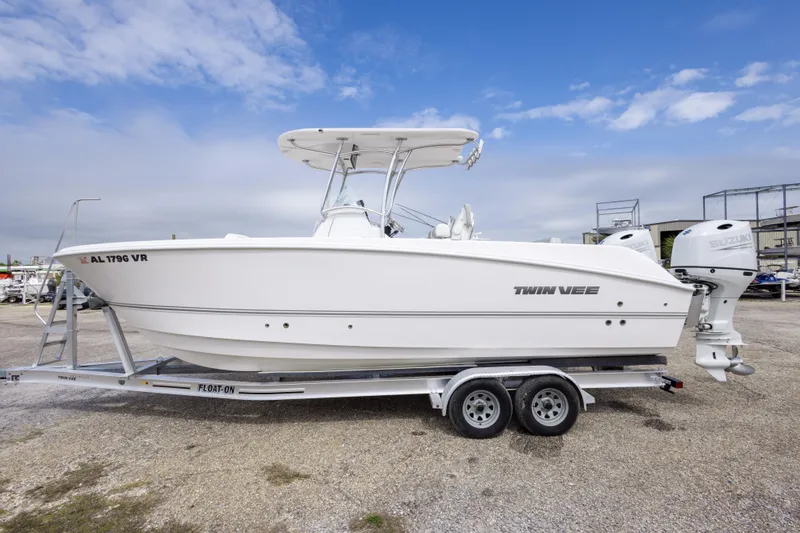Slide: The Image of 2022 Twin Vee 240 GFX CC boat on trailer, side view, under blue sky. - 8