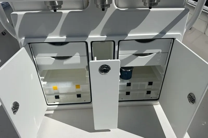 Slide: The Image of 2021 Regulator 28 Forward Seating boat storage compartments with open doors and organized interior. - 16