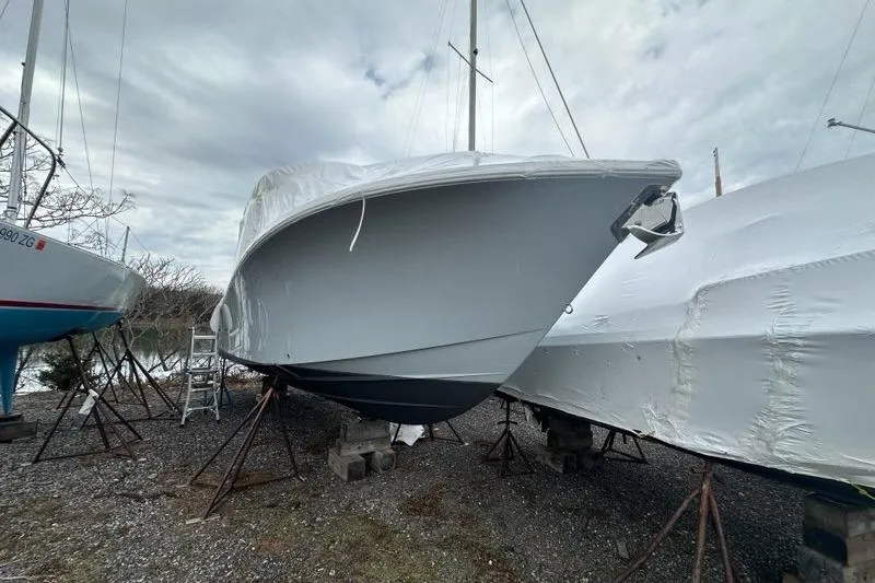 Slide: The Image of 2021 Regulator 28 Forward Seating boat covered and stored on land. - 3