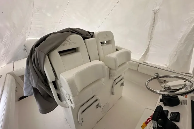 Slide: The Image of 2021 Regulator 28 Forward Seating boat interior with helm and cushioned seats. - 4