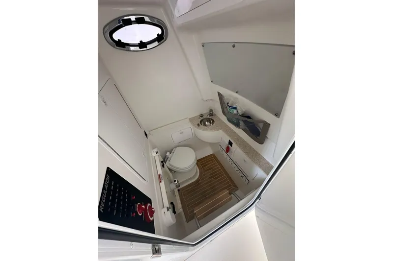 Slide: The Image of 2021 Regulator 28 Forward Seating boat interior with compact bathroom amenities. - 8