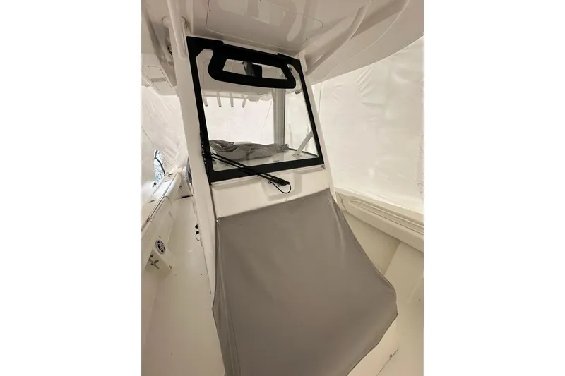 Slide: The Image of 2021 Regulator 28 Forward Seating boat interior with protective cover and windshield. - 9