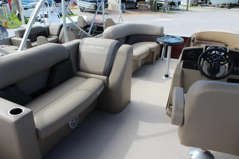 Slide: The Image of 2026 Sylvan Mirage Fish 820 Party Fish pontoon boat interior with plush seating and steering console. - 2