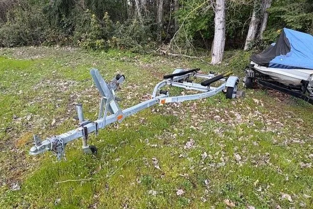 Slide: The Image of Boat trailer on grass near trees, designed for 1988 Boston Whaler 130 Super Sport. - 5