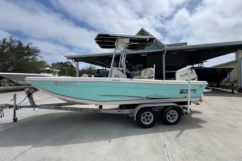 The Image of 2019 Carolina Skiff 21 Ultra Elite boat on trailer, parked outdoors under cloudy sky. - 1