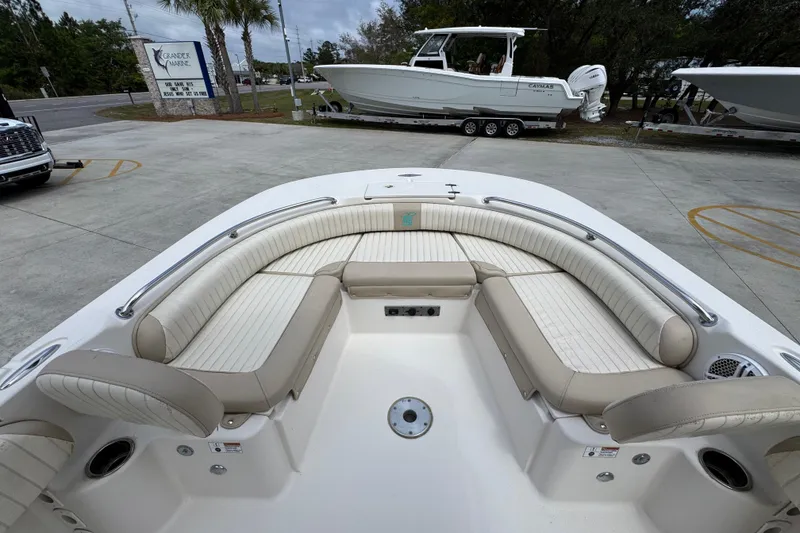 Slide: The Image of 2019 Carolina Skiff 21 Ultra Elite boat with spacious seating, parked at a marina. - 17