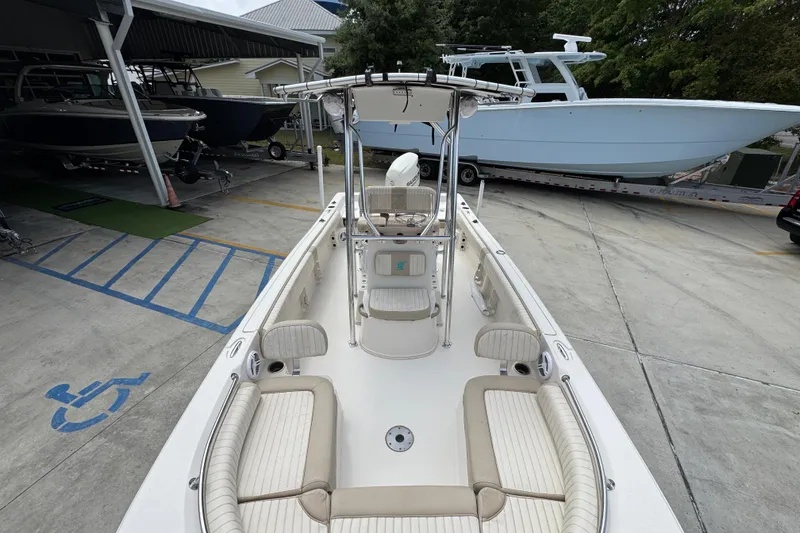 Slide: The Image of 2019 Carolina Skiff 21 Ultra Elite boat with spacious seating, parked in a marina. - 21