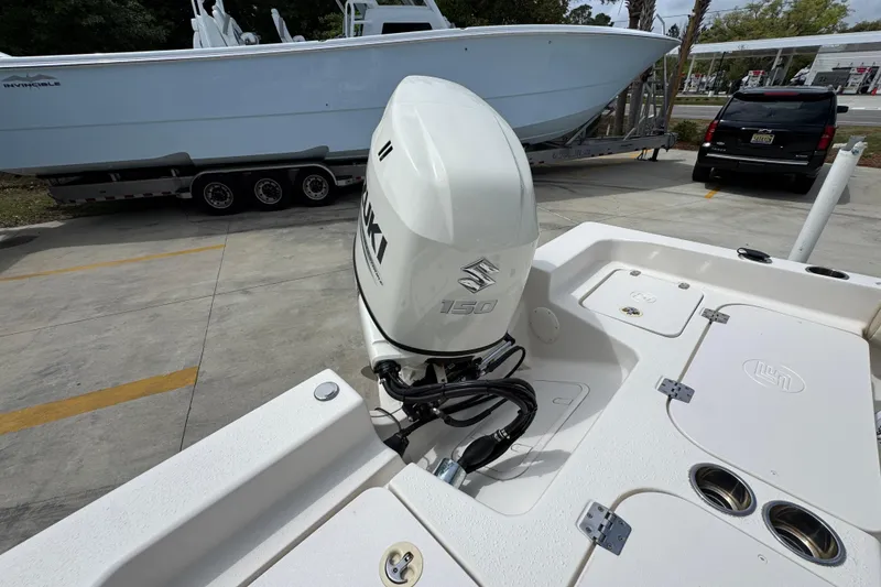 Slide: The Image of 2019 Carolina Skiff 21 Ultra Elite with Suzuki 150 outboard motor in a parking lot. - 39