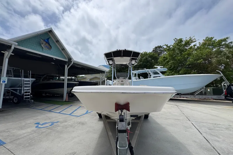 Slide: The Image of 2019 Carolina Skiff 21 Ultra Elite boat on trailer at marina, cloudy sky background. - 5