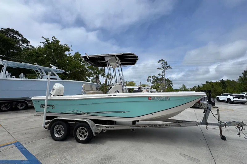 Slide: The Image of 2019 Carolina Skiff 21 Ultra Elite boat on trailer, parked outdoors under cloudy sky. - 8