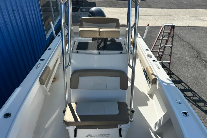 Slide: The Image of 2019 Parker 21 Special Edition boat interior with seating and console, docked near a blue building. - 16