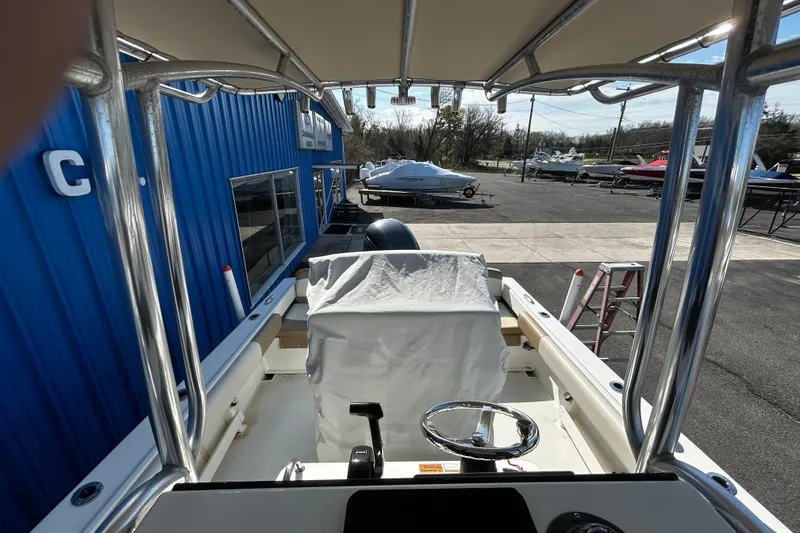 Slide: The Image of 2019 Parker 21 Special Edition boat interior at a marina, featuring steering wheel and covered console. - 21