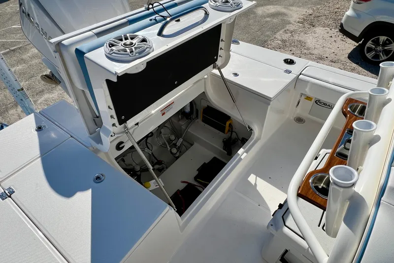 Slide: The Image of 2026 Robalo 246 Cayman boat interior with open storage compartment and rod holders. - 13