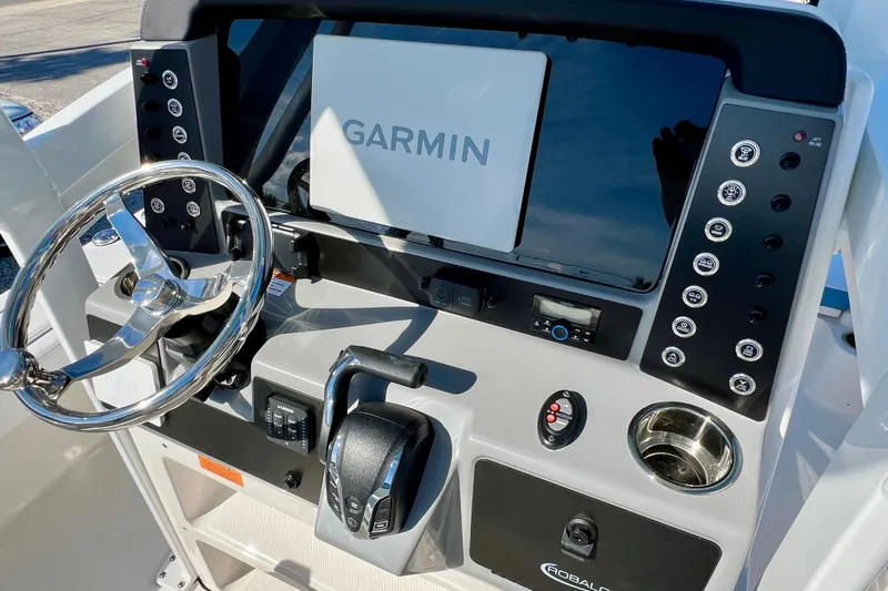 Slide: The Image of 2026 Robalo 246 Cayman boat dashboard with Garmin navigation system and steering wheel. - 18