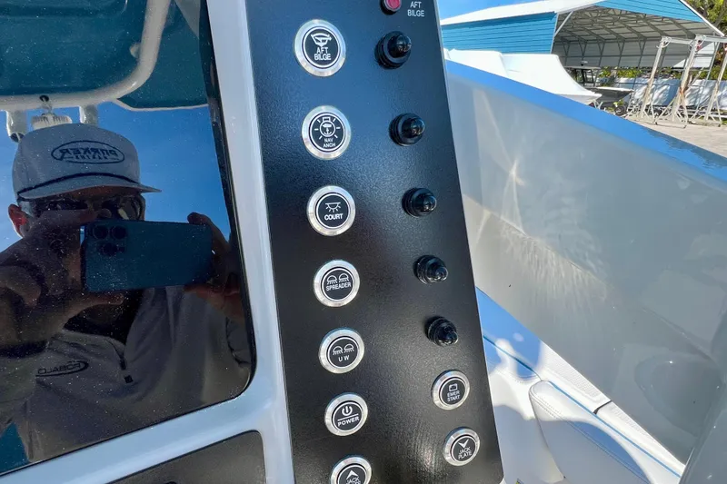 Slide: The Image of Control panel of 2026 Robalo 246 Cayman boat with various labeled switches. - 19