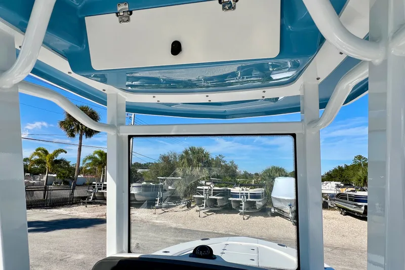 Slide: The Image of 2026 Robalo 246 Cayman boat interior with blue ceiling and clear windshield view. - 22