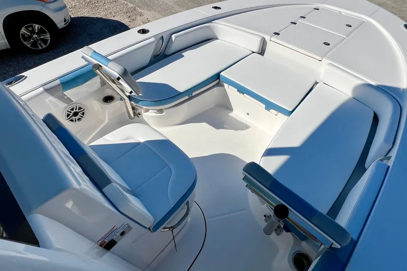 Slide: The Image of 2026 Robalo 246 Cayman boat interior with blue and white seating, showcasing spacious design. - 23